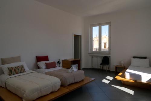una camera con due letti, un divano e una finestra di Sopramoltivolti a Palermo