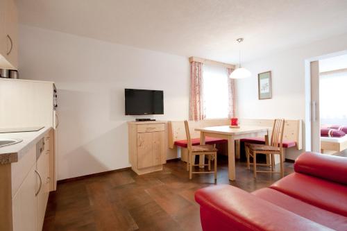 a living room with a couch and a table with a tv at Bacher Ferienwohnungen in Virgen