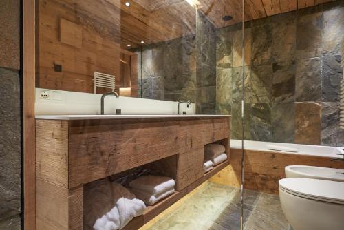 uma casa de banho com um lavatório, uma banheira e um WC. em HOTEL de LEN em Cortina dʼAmpezzo