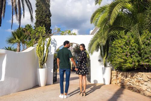 a man and a woman walking down a sidewalk at Casa Munich in Ses Salines