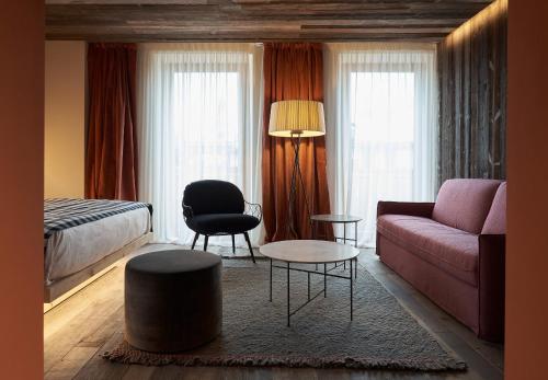 a living room with a couch and a bed at HOTEL de LEN in Cortina dʼAmpezzo