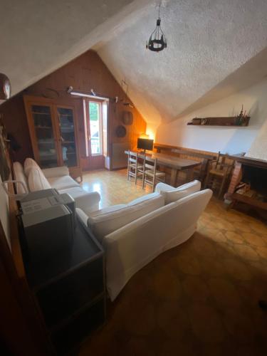 ein Wohnzimmer mit weißen Sofas und einem Tisch in der Unterkunft Roccaraso in tasca in Roccaraso