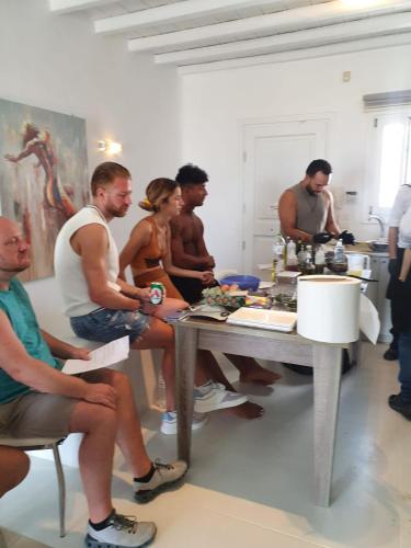een groep mensen die rond een tafel in een kamer zitten bij Villa Harmony in Kalafatis
