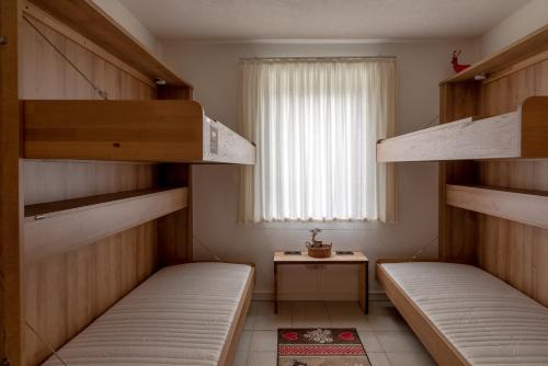 two bunk beds in a room with a window at Chalet Love The Alps by All in One Apartments in Zell am See