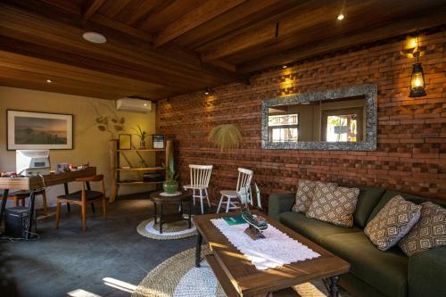 a living room with a couch and a brick wall at Menjangan Ecolodge - CHSE Certified in Banyuwedang