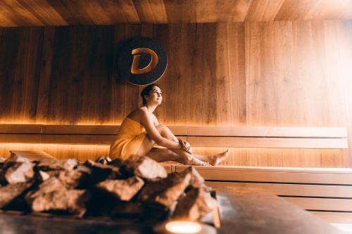 a man is sitting in a sauna at Dilly - Das Nationalpark Resort in Windischgarsten