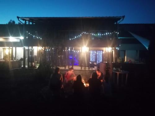 a group of people sitting in front of a building at night at Silver Horse Ranch in Békés