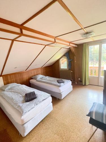 2 camas en una habitación con techo en NEB-THUN LODGE`s Seehaus 1 Gwatt, en Thun