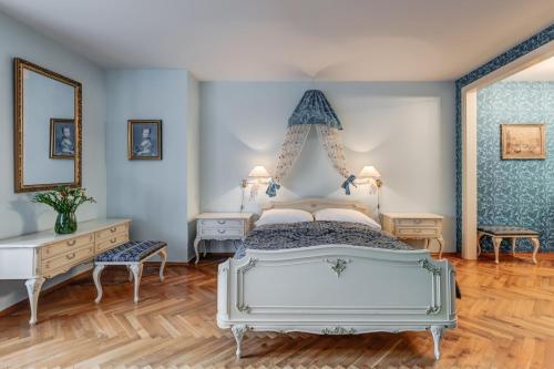 a bedroom with a white bed and blue walls at Vila Austerlitz in Slavkov u Brna