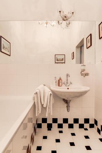 a bathroom with a sink and a black and white tile floor at Vila Austerlitz in Slavkov u Brna