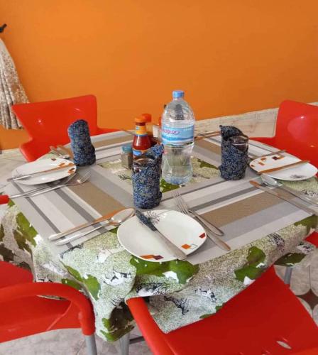 a table with plates and bottles of water on it at Africa Lodge Arusha in Nkoaranga