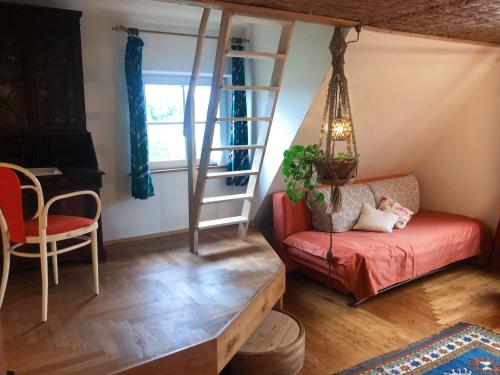 a living room with a staircase and a red couch at Das blaue Haus in Pfullendorf