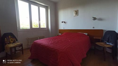 a bedroom with a red bed and a window at Le Flaugergues in Rodez