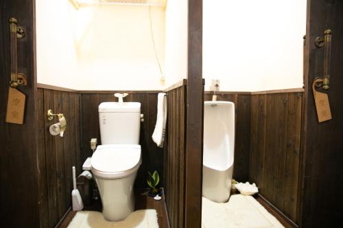 a bathroom with a toilet and a urinal and a window at Kizuna Guesthouse in Kizugawa
