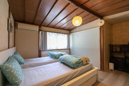 a bedroom with two beds in a room at Kizuna Guesthouse in Kizugawa