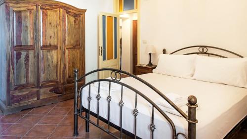 a bedroom with a bed and a wooden cabinet at Welcomely - Casa Avineira in Alghero