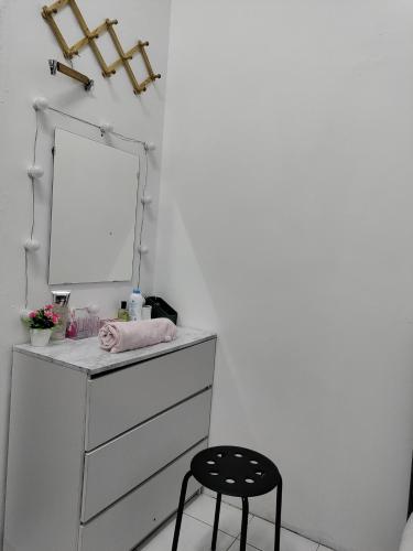 a bathroom with a vanity with a mirror and a stool at Ubaid Homestay in Seremban