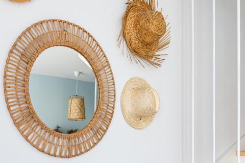 a wicker mirror hanging on a wall with a hat at Holiday Point in Międzywodzie