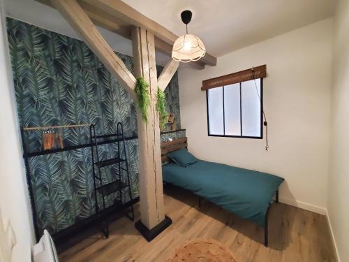 - une chambre avec un lit vert dans une pièce dotée d'une fenêtre dans l'établissement 