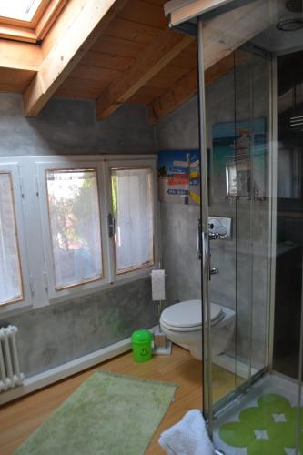 a bathroom with a toilet and a glass shower at B&B Cappuccini in Schio