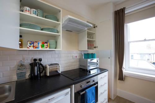 a kitchen with a black counter top and a window at Brewhouse and Kitchen in Bournemouth