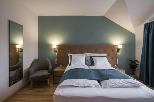 a bedroom with a large bed and a chair at Kistücsök Food & Room in Balatonszemes