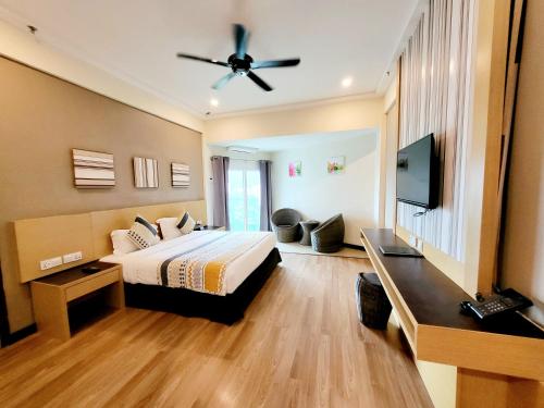 a hotel room with a bed and a flat screen tv at Langkawi Seaview Hotel in Kuah