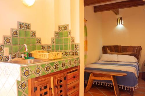 a kitchen with a sink and a bed in a room at Hotel Casamar Suites in Puerto Escondido