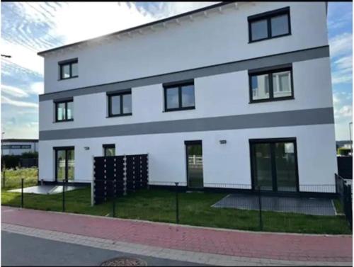 un edificio blanco con ventanas negras en una calle en Luxusvilla Neubau 1 en Oberasbach
