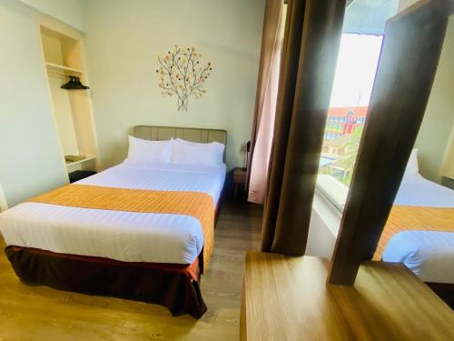 a hotel room with two beds and a window at Seaview Apartment in Kuah