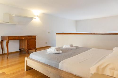 een slaapkamer met een bed en een houten tafel bij Nice one bedroom in historical building in Florence