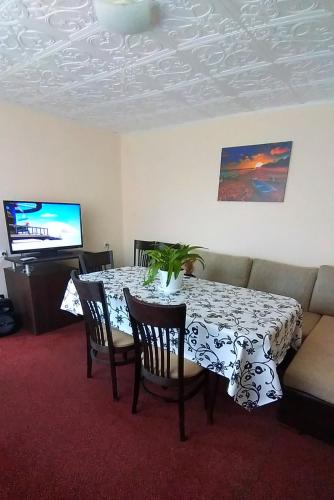 a dining room table and chairs with a table and a couch at Rose & Water Guest house in Pavel Banya