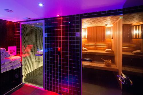 La salle de bains est pourvue d'une douche avec des lumières violettes. dans l'établissement Platine Hotel, à Paris