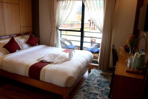 a bedroom with a bed and a large window at Hotel Family Ties Pvt. Ltd. in Kathmandu