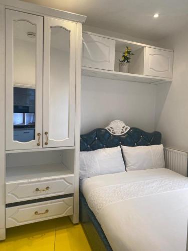 niewielka sypialnia z łóżkiem i szafką w obiekcie Ziggla Luxury Apartments w Londynie