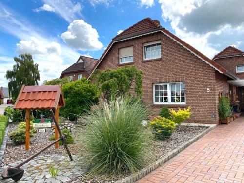 a brick house with a garden in front of it at Ferienwohnung Brentano_ 65230 in Moormerland