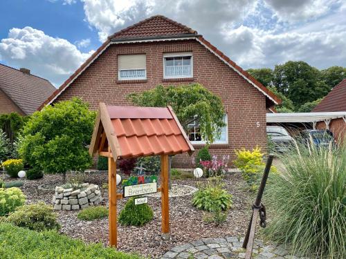a garden in front of a house with a roof at Ferienwohnung Brentano_ 65230 in Moormerland