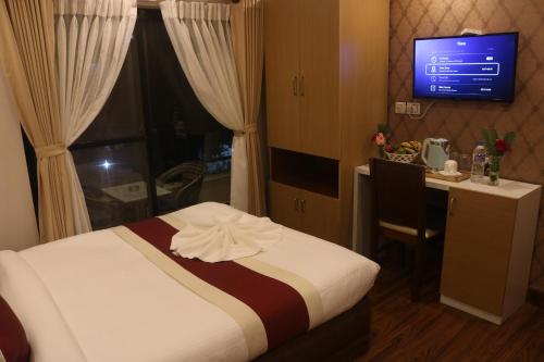 a bedroom with a bed and a desk and a television at Hotel Family Ties Pvt. Ltd. in Kathmandu