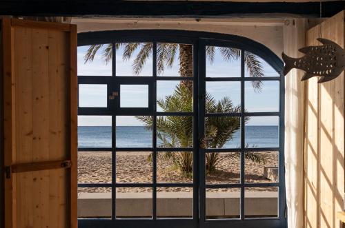 an open door with a view of the beach at La casa de las barcas Suite a pie de playa in Calafell