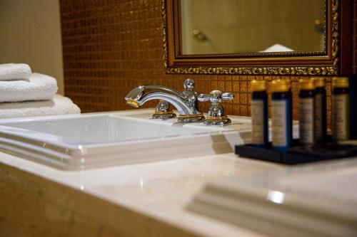 a bathroom sink with a faucet and a mirror at Boutique Hotel Slávia in Košice