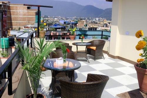 eine Terrasse mit Tischen und Stühlen auf dem Balkon in der Unterkunft Hotel Family Ties Pvt. Ltd. in Kathmandu