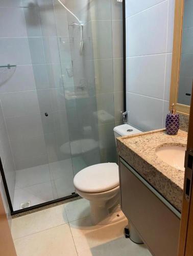 a bathroom with a shower and a toilet and a sink at Manaíra Apart Hotel in João Pessoa
