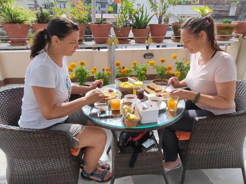 dos mujeres sentadas en una mesa comiendo comida en Hotel Family Ties Pvt. Ltd., en Katmandú