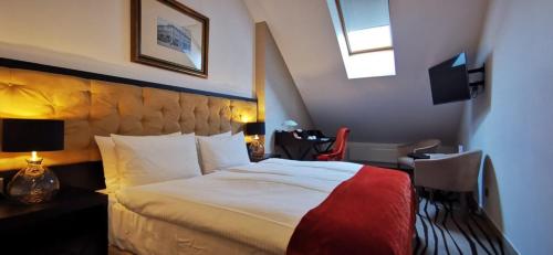 a hotel room with a bed and a desk and a window at Boutique Hotel Slávia in Košice