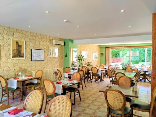 um restaurante com mesas e cadeiras num quarto em Les Ambassadeurs Hotel - Logis em Souillac