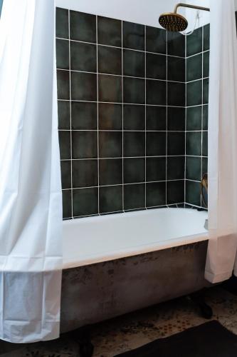 a bathtub with a shower curtain in a bathroom at Rakstvežu apartamenti in Liepāja