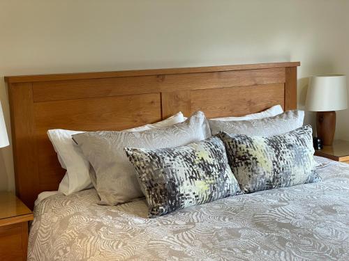 a bed with four pillows on top of it at White Lodge B&B in Cooksbridge
