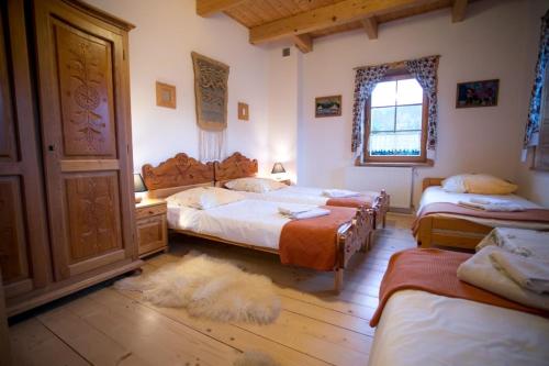 a bedroom with three beds and a large white dog laying on the floor at Willa Zawadówka in Szczawnica