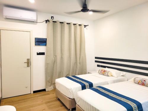 two beds in a room with white walls at Belvedere Thoddoo in Thoddoo