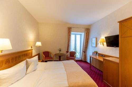 a hotel room with a large bed and a desk at Landgasthof Adler in Breisach am Rhein